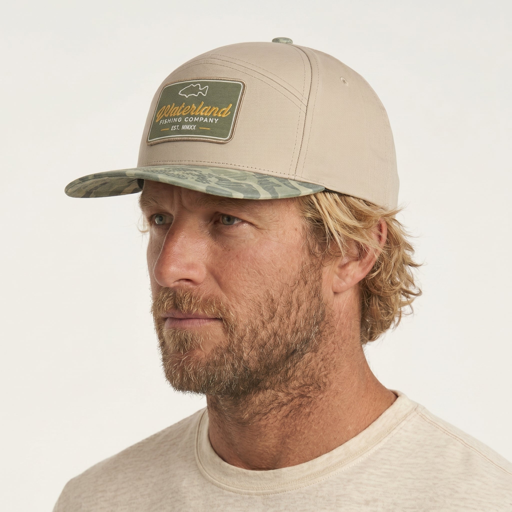 Man wearing a beige cap with a patch on a white background
