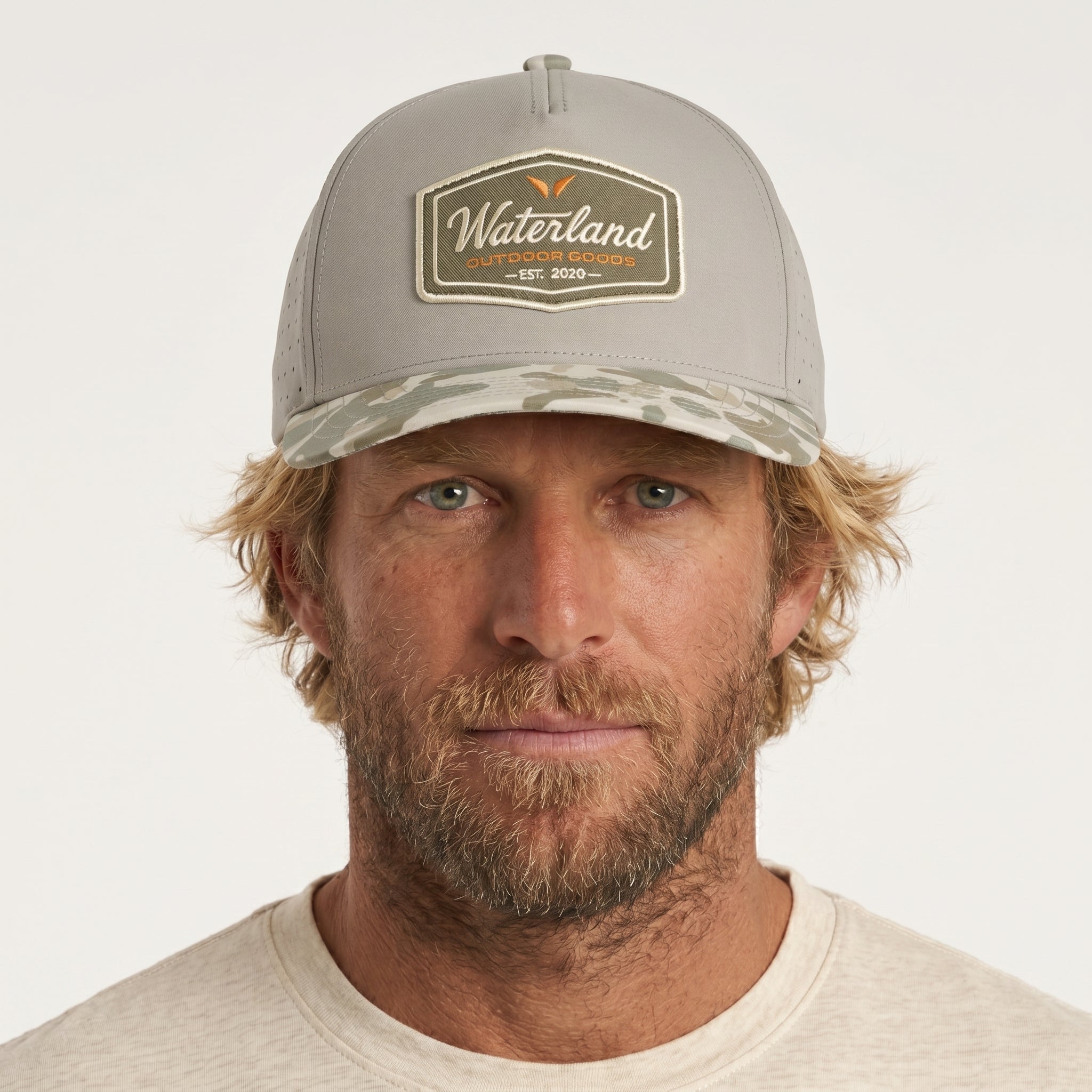 Man wearing a gray cap with a logo on a white background
