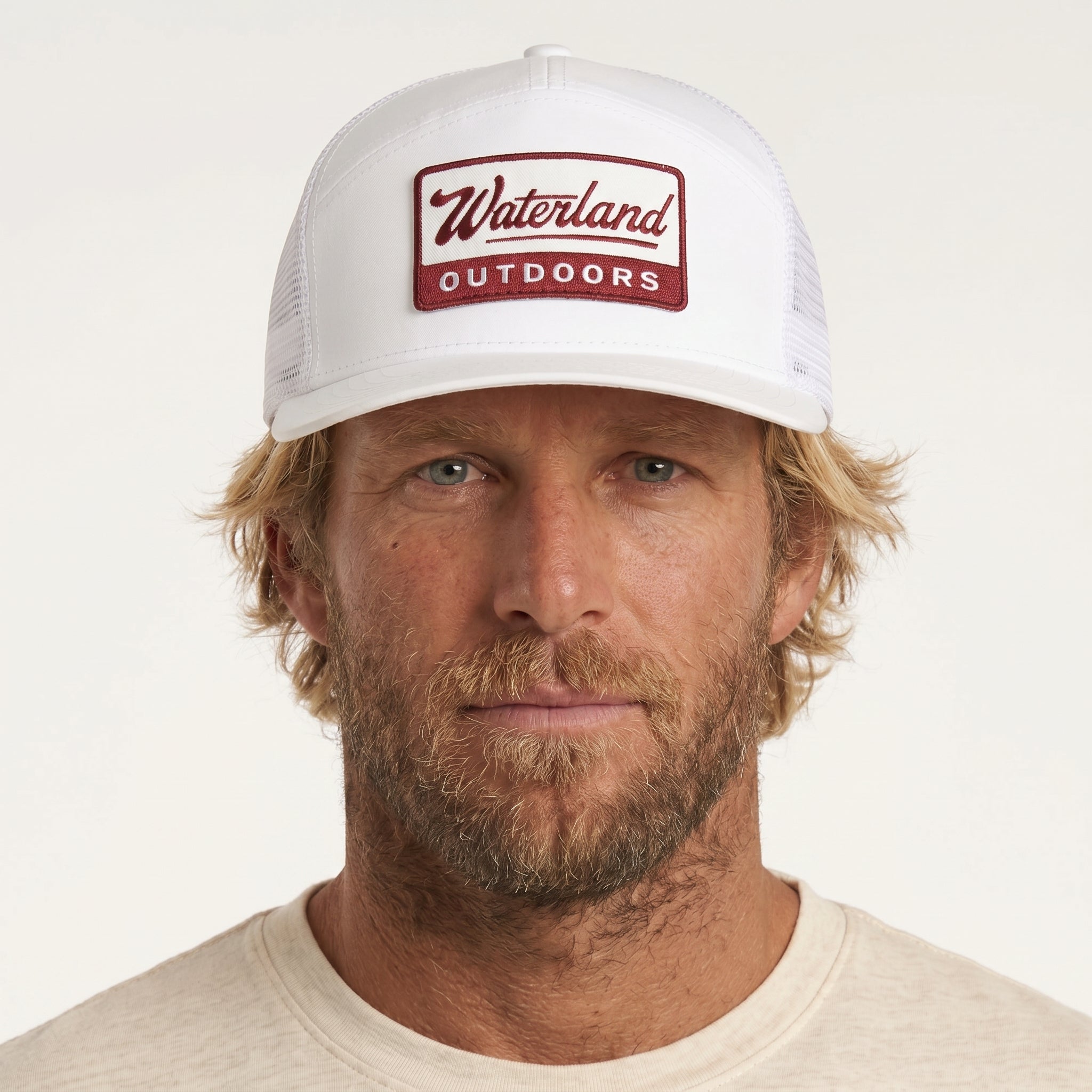 Man wearing a white cap with 'Waterland Outdoors' logo on a light gray background