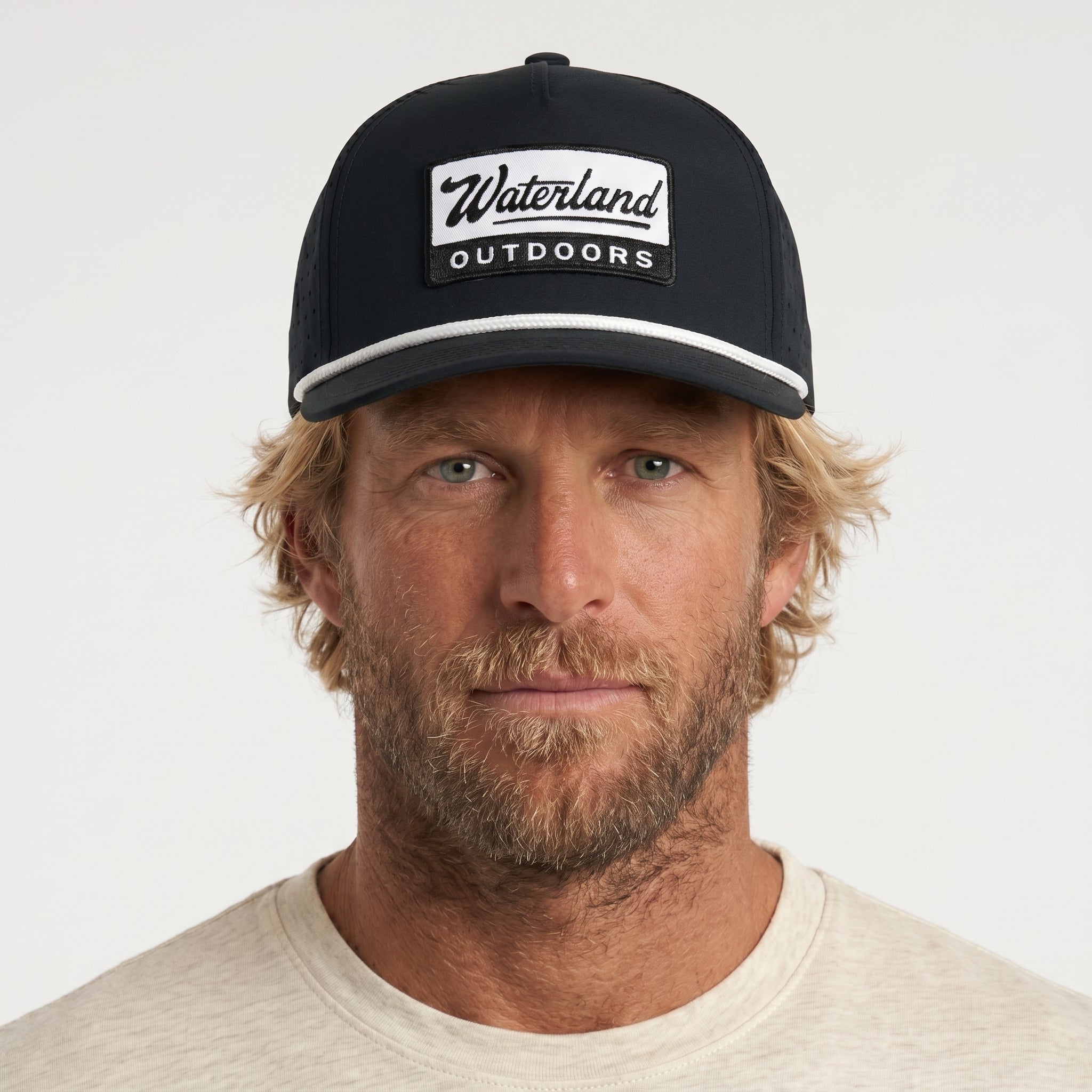 Man wearing a black cap with 'Waterland Outdoors' logo on a white background