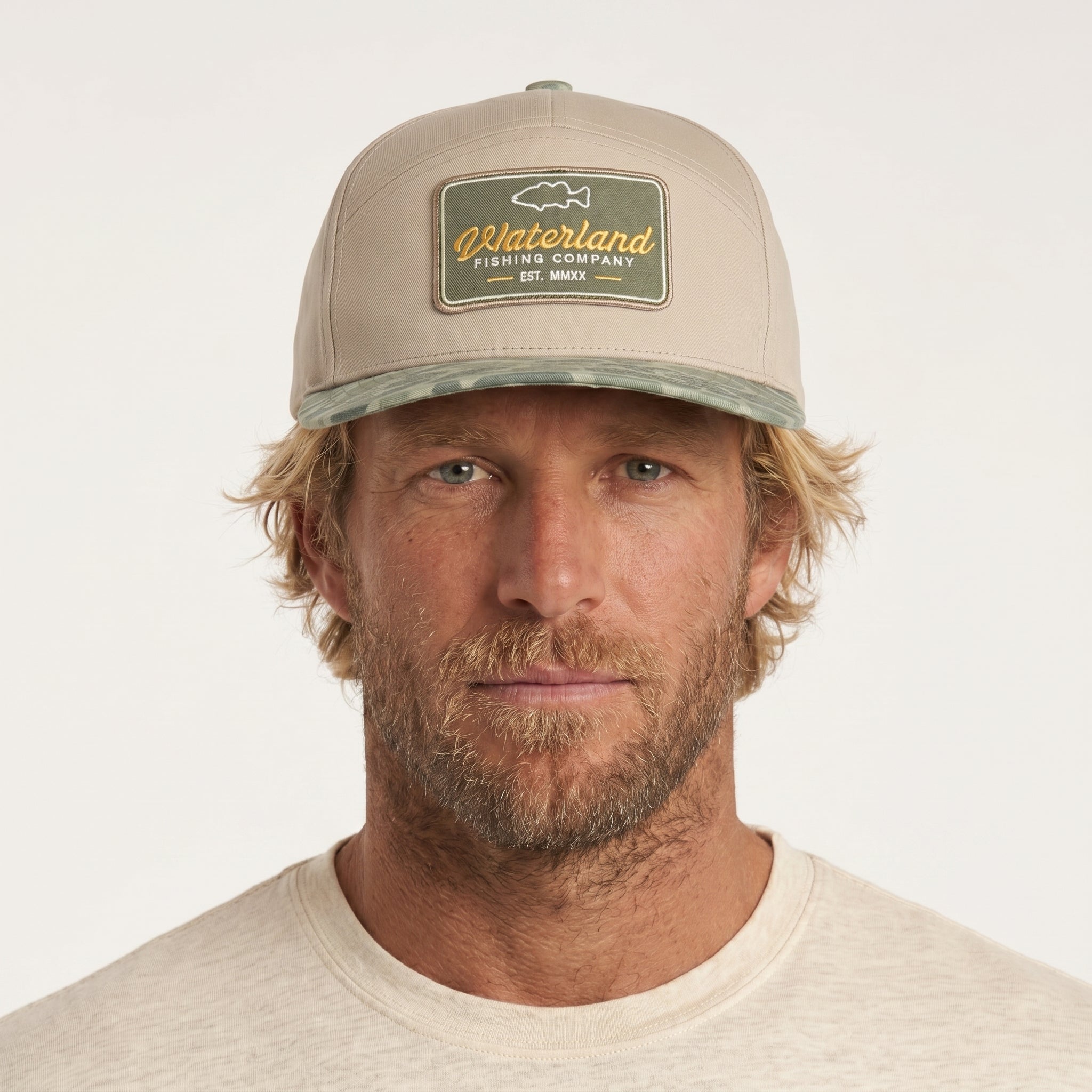Man wearing a beige cap with a logo on a white background