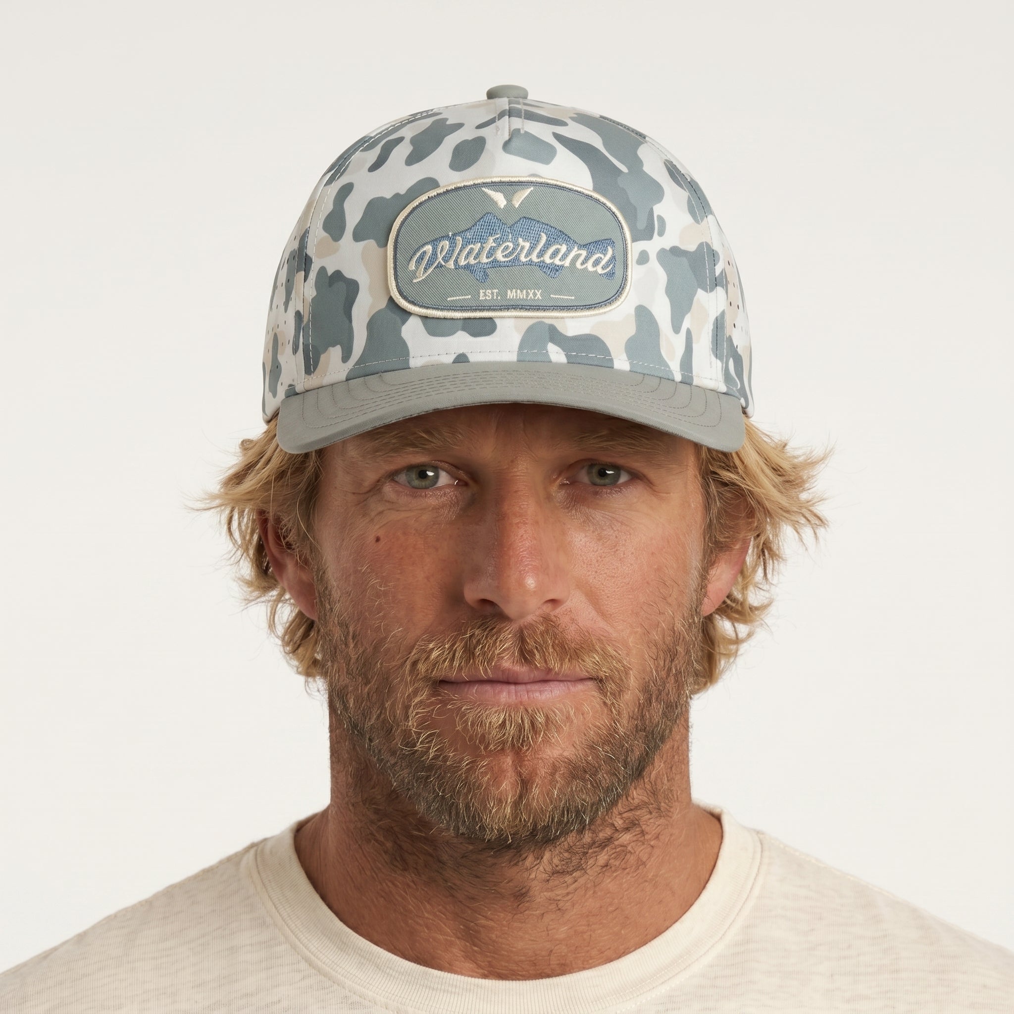 Man wearing a camouflage cap with 'Waterland' logo on a white background